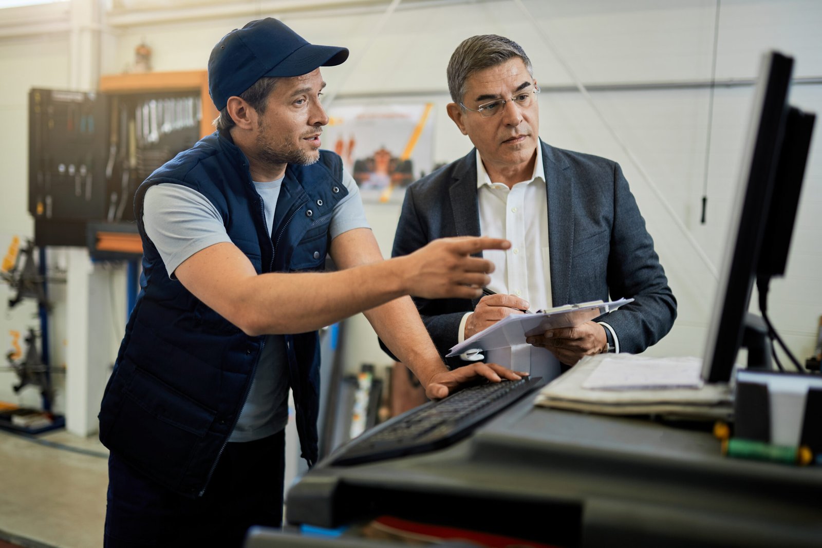 Auto repairman and manager cooperating while using computer in a 3Com Baseline Switch , 24 Port (Model : 2226 Plus)